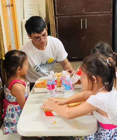 A Bednbody volunteer sharing a meal with children