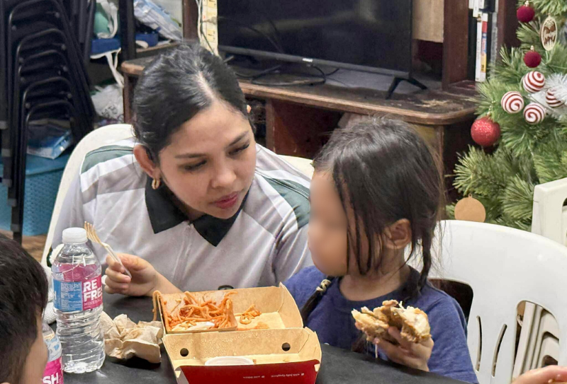A Bednbody volunteer sharing a meal with a child